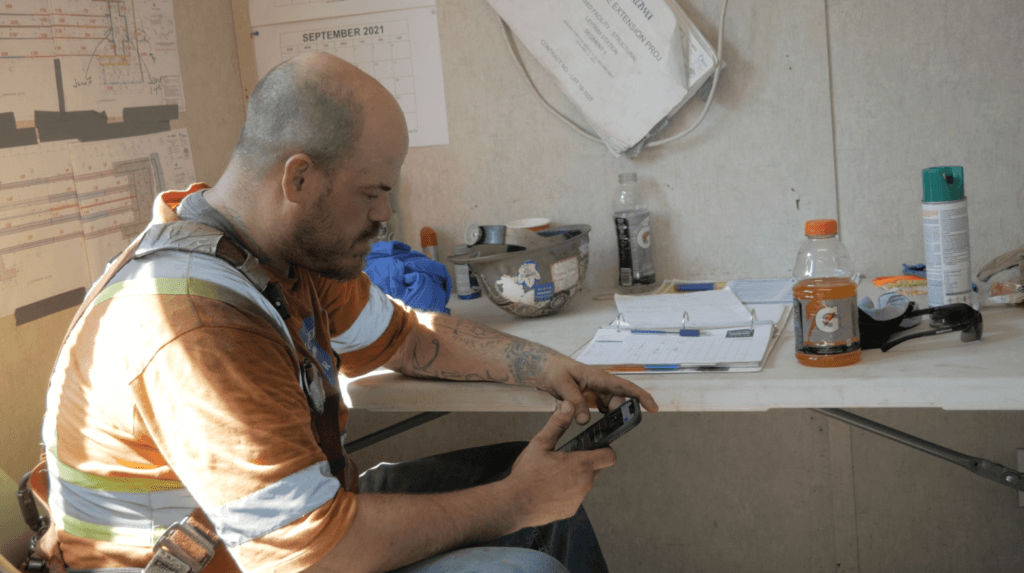 a construction worker using his phone to access forms and important site information