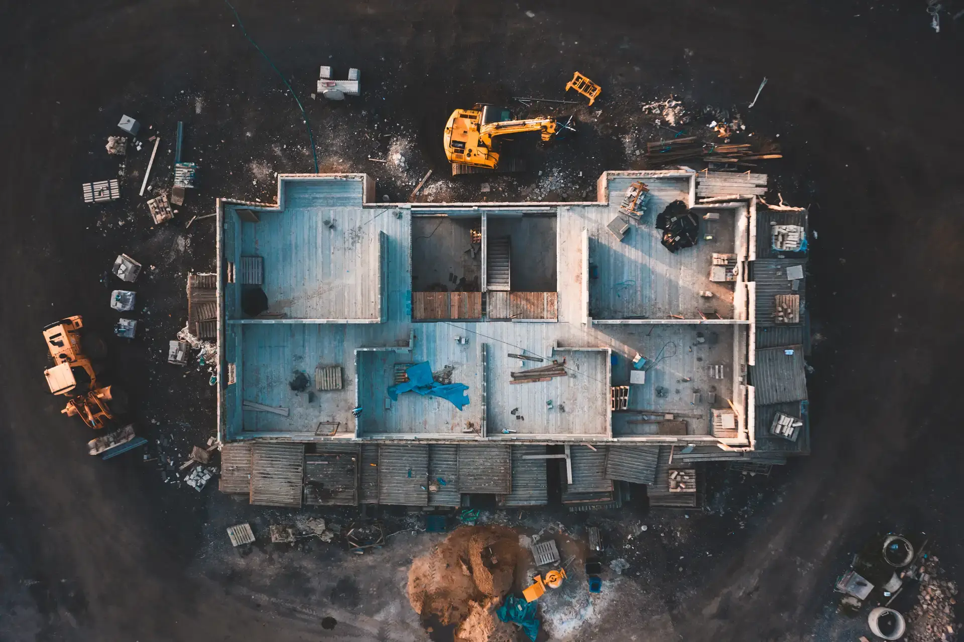 aerial view of a house bring framed, with excavator and bulldozer