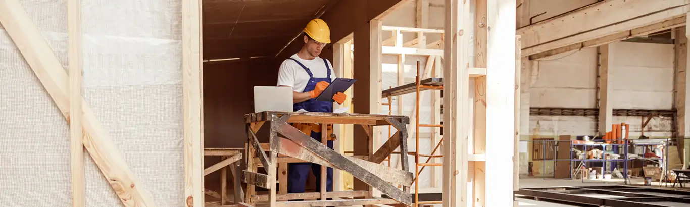 Male builder writing on clipboard