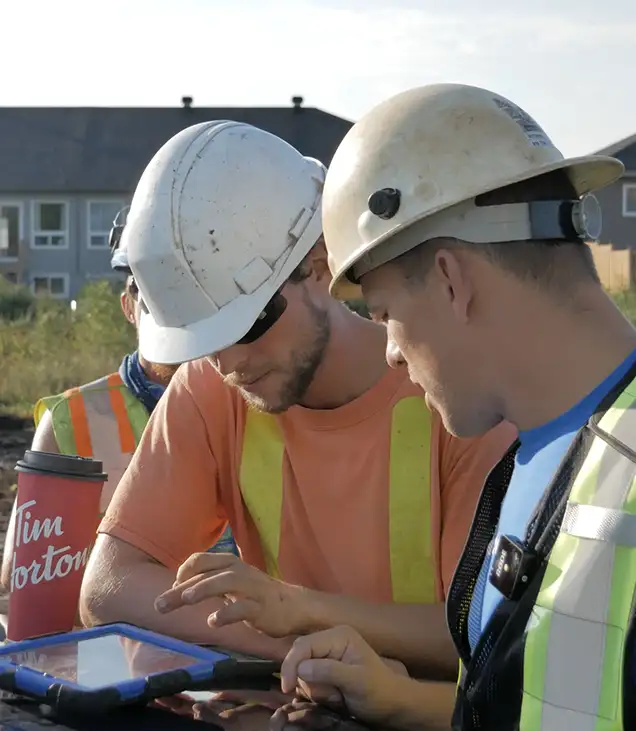 two men on jobsite looking at an ipad