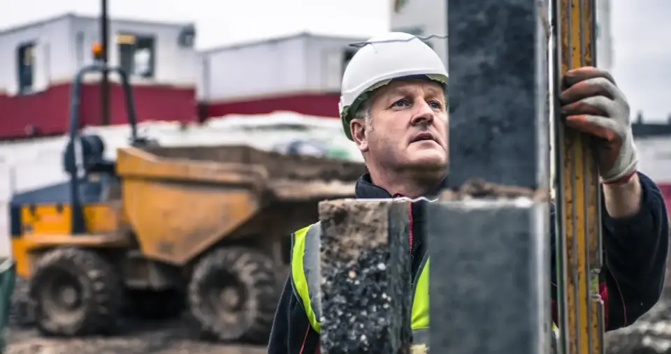 A construction worker inspecting a steel column