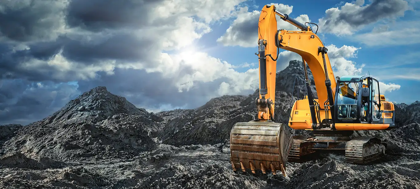 Yellow excavator moving stone from quarry