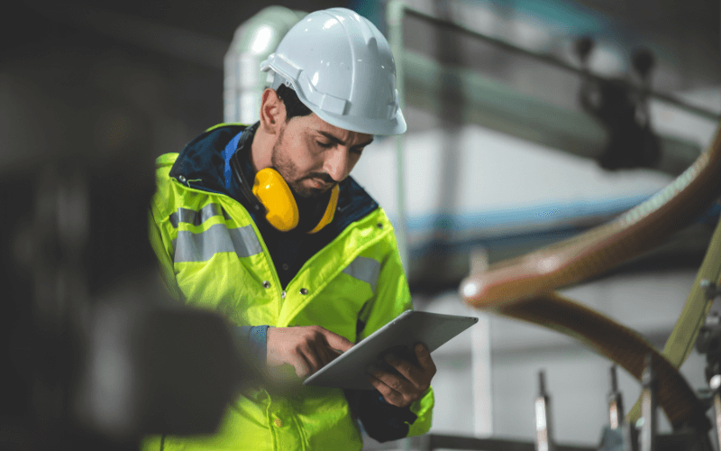 a construction worker looking at a tablet with digital documentation