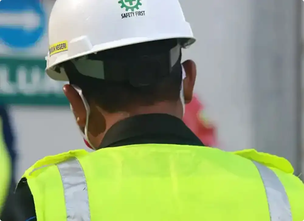 close up of the back of a construction worker wearing a hardhat that says "safety first"