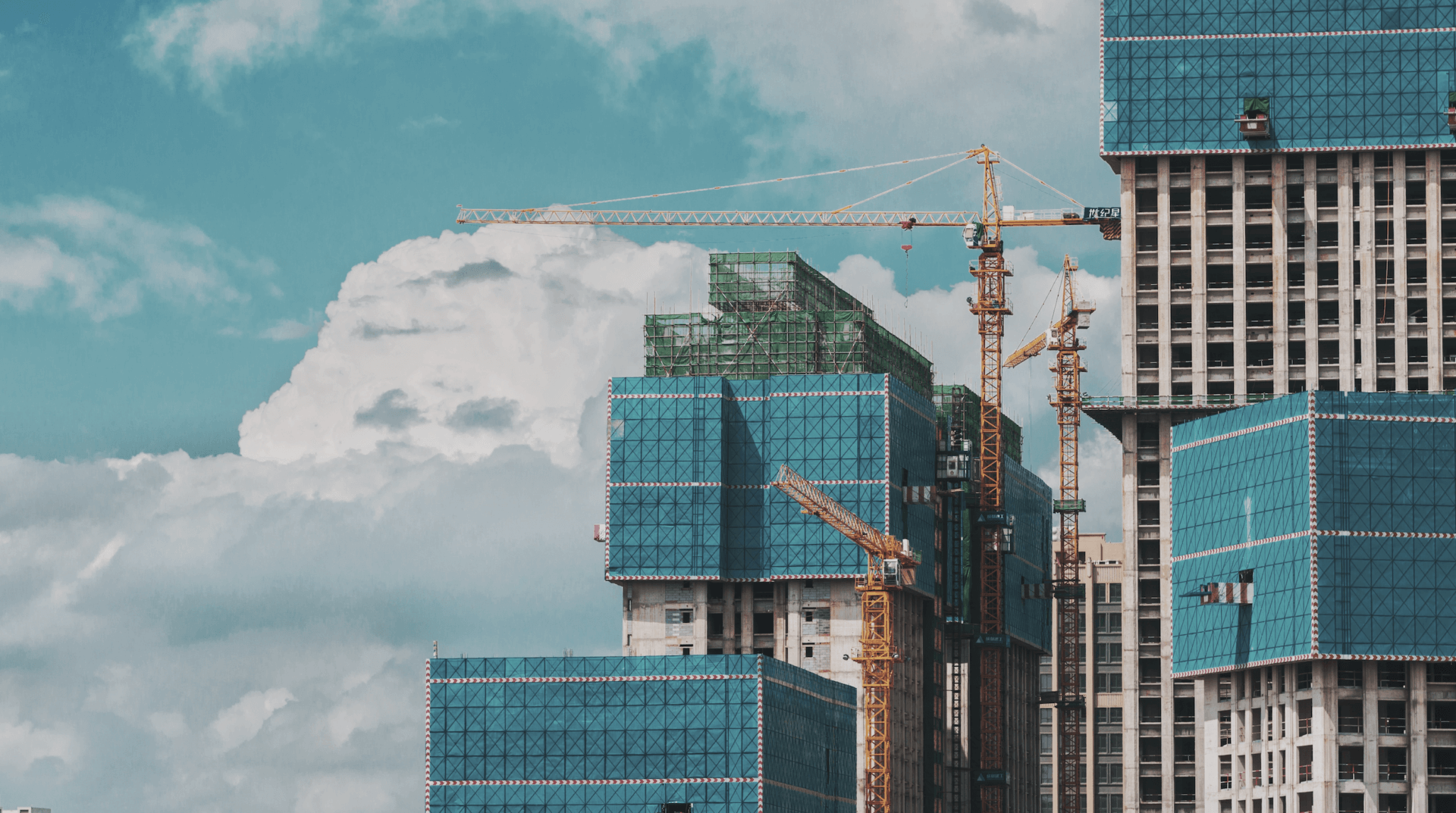 high rise building being build with three cranes