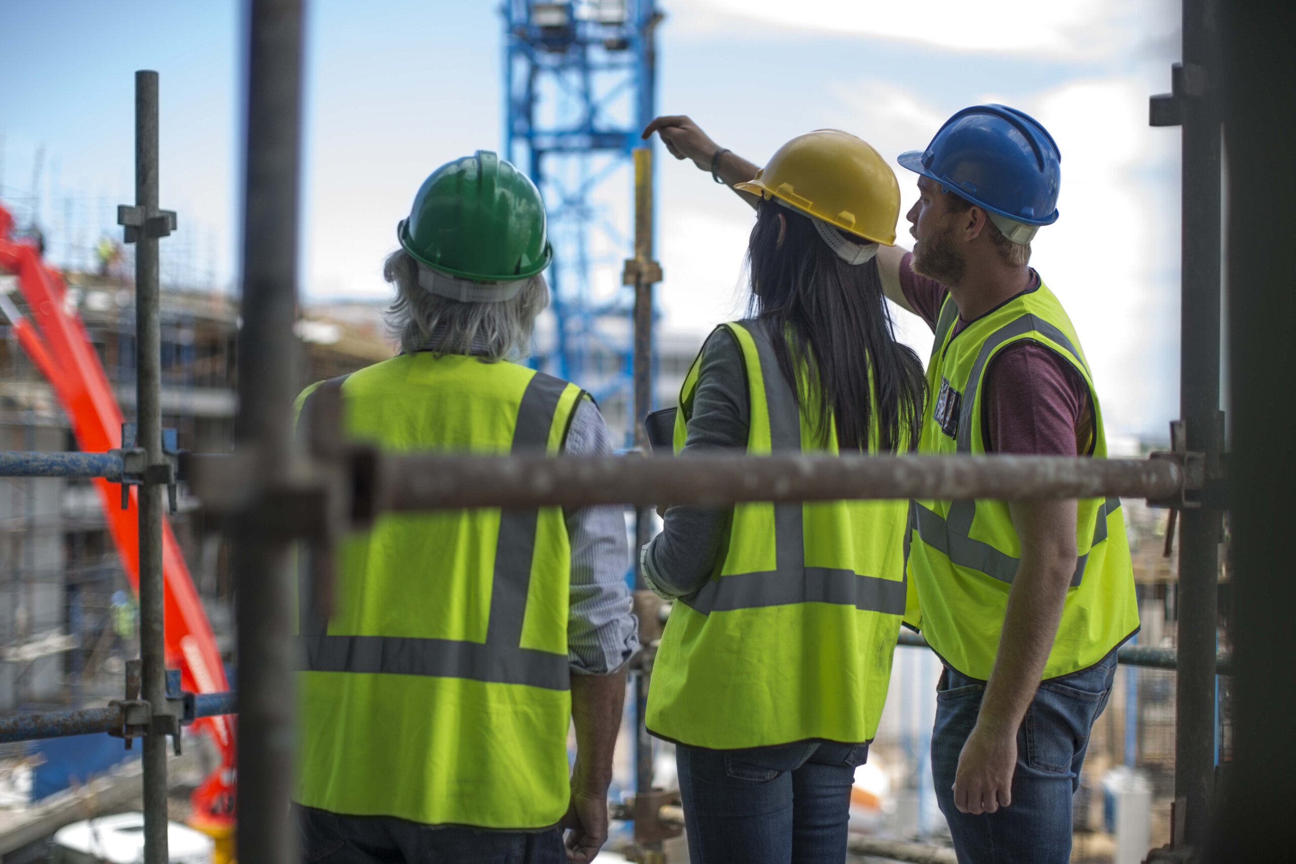 Construction worker talking to man and woman on a construction site