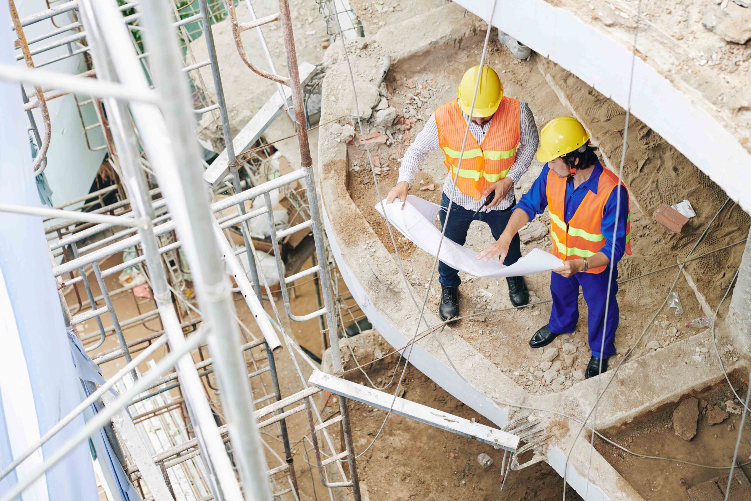 construction workers looking at a drawing on a construction site