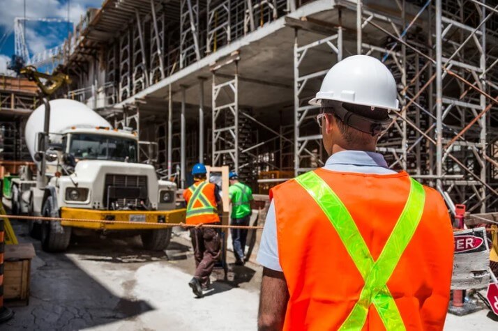 a construction site supervisor watching over the crew