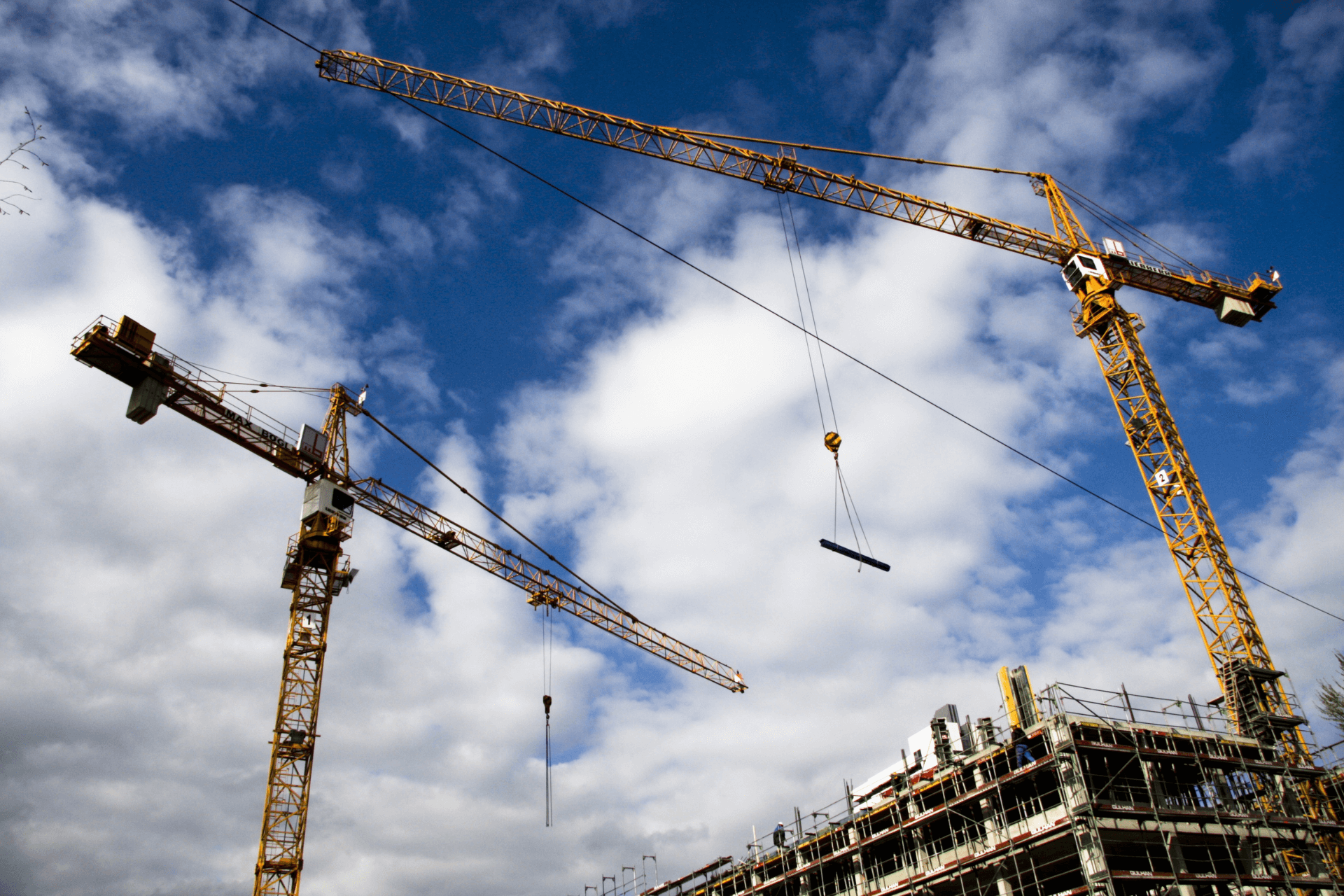 image of a crane lifting a beam on a construction site