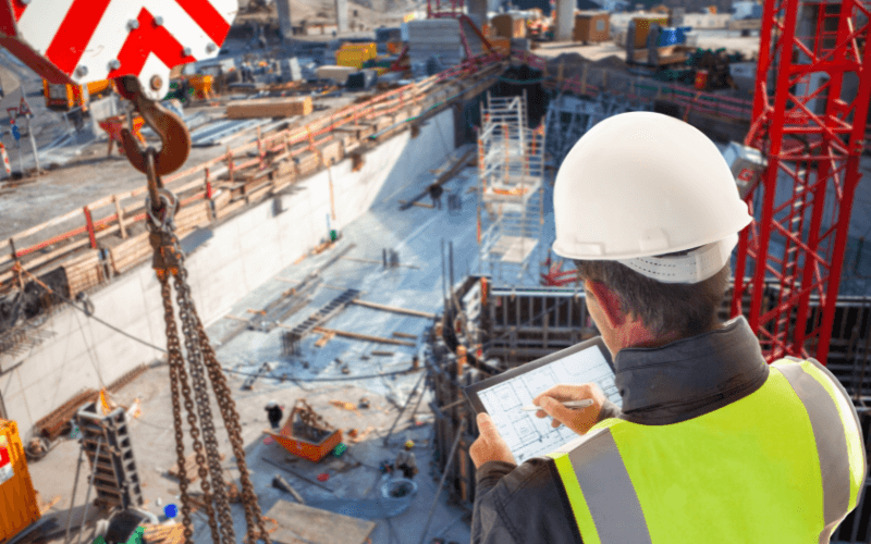 construction worker looking at a digital blueprint on the jobsite.