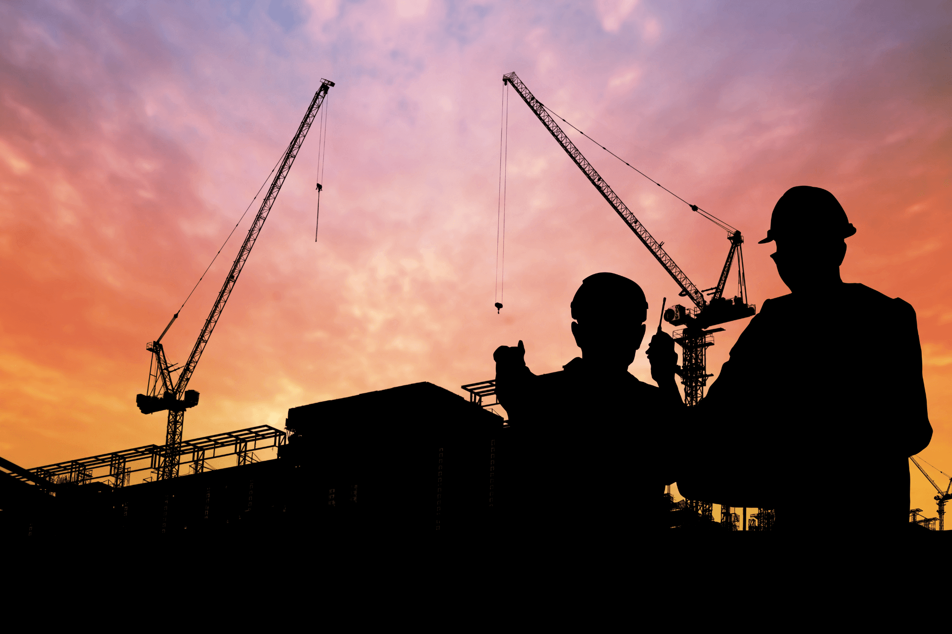 construction works and cranes against a sunset background