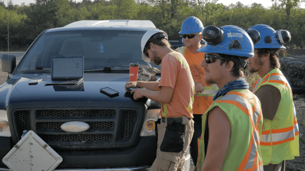 a team of construction workers receiving training on how to use their construction management software